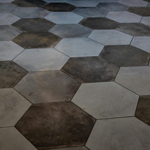 Elegant hexagonal floor tiles create a striking marble pattern, perfect for modern interiors.